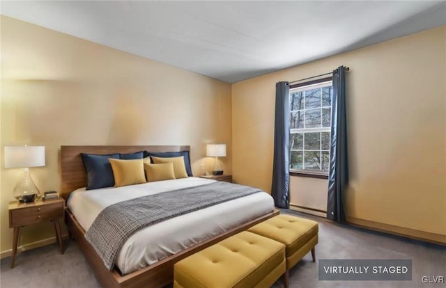 bedroom with carpet and a baseboard heating unit