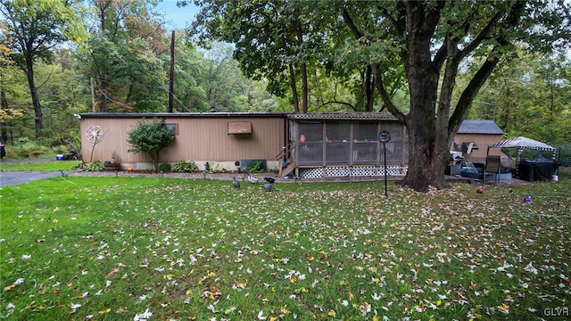 view of front of home featuring a sunroom, a front lawn, and a gazebo