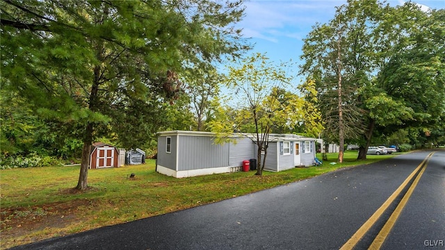 manufactured / mobile home featuring a front yard and a storage unit