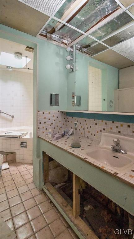898 Browntown Rd, Plainfield Twp, PA 18064 - bathroom with vanity, tile patterned floors, decorative backsplash, and a tub to relax in