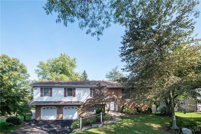 bi-level home featuring a garage and a front lawn