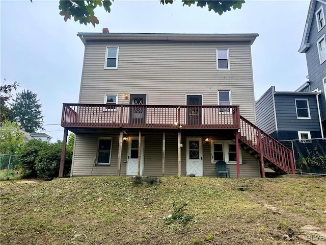 rear view of house with a deck and a yard