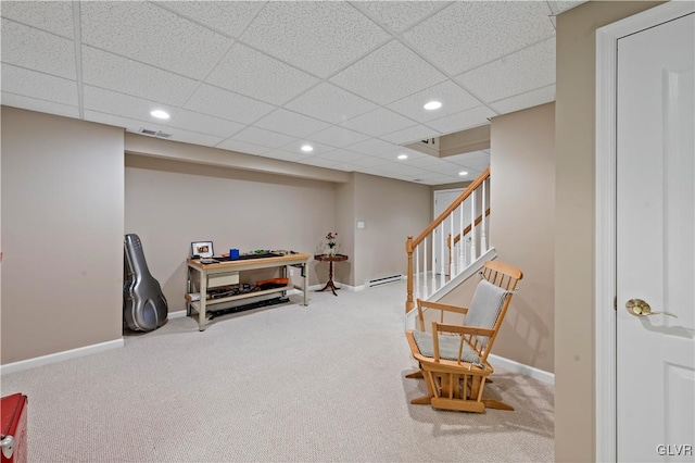 living area featuring carpet floors and a paneled ceiling