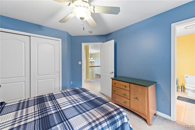 bedroom featuring ensuite bath, a closet, light colored carpet, and ceiling fan