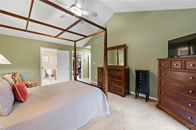 carpeted bedroom with ceiling fan, vaulted ceiling, and ensuite bathroom