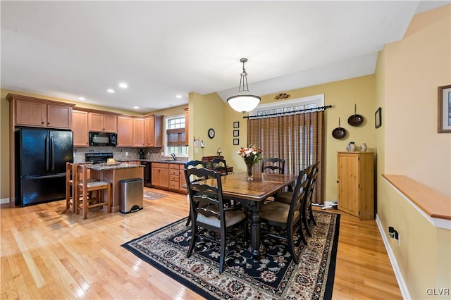 dining area with light hardwood / wood-style flooring and sink