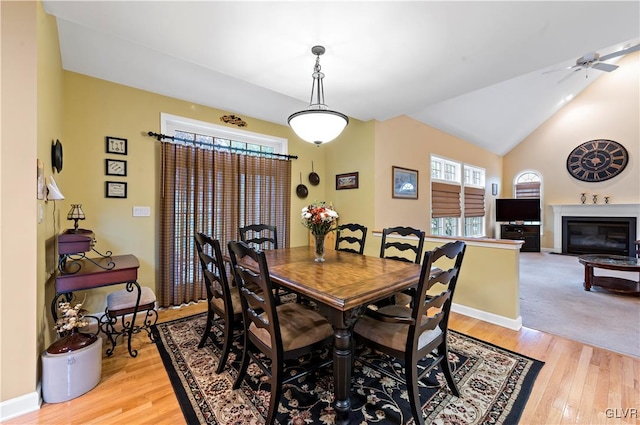 dining space featuring ceiling fan, lofted ceiling, light wood-type flooring, and a wealth of natural light