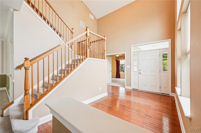 foyer with hardwood / wood-style flooring and high vaulted ceiling