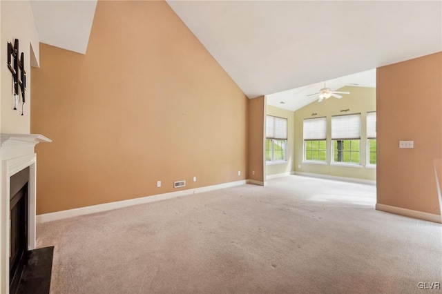 unfurnished living room featuring vaulted ceiling, ceiling fan, and light carpet