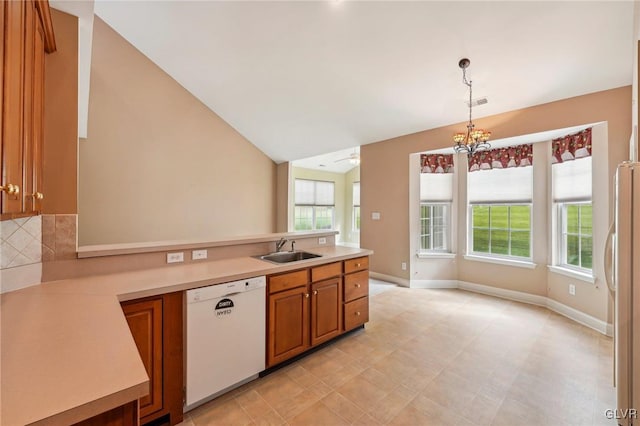 kitchen featuring decorative light fixtures, lofted ceiling, sink, white appliances, and ceiling fan with notable chandelier