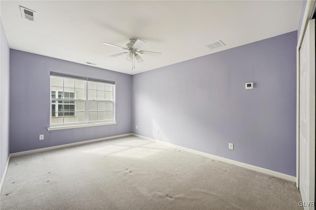 spare room with ceiling fan and light colored carpet