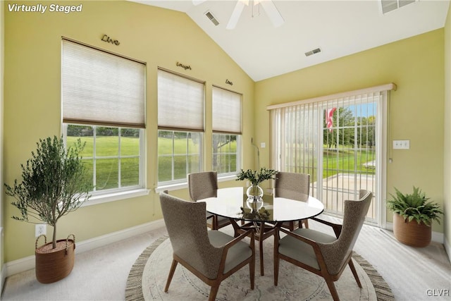 carpeted dining room featuring ceiling fan and vaulted ceiling