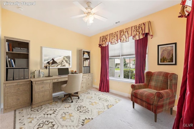 carpeted home office featuring ceiling fan