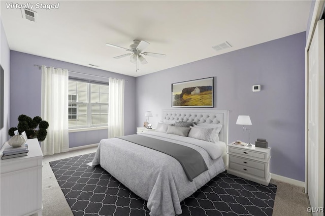 bedroom with ceiling fan, dark carpet, and a closet