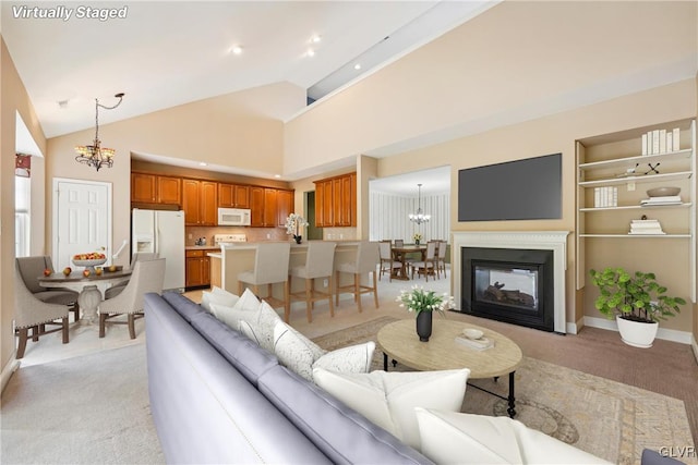 living room with built in shelves, a multi sided fireplace, a chandelier, and high vaulted ceiling