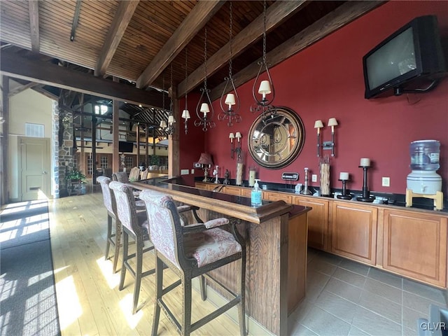 bar with wooden ceiling, beam ceiling, and wood-type flooring