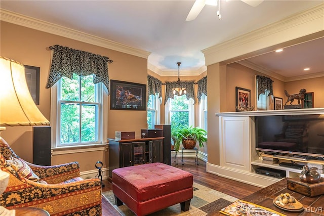 living room featuring ceiling fan with notable chandelier, dark wood-type flooring, and crown molding