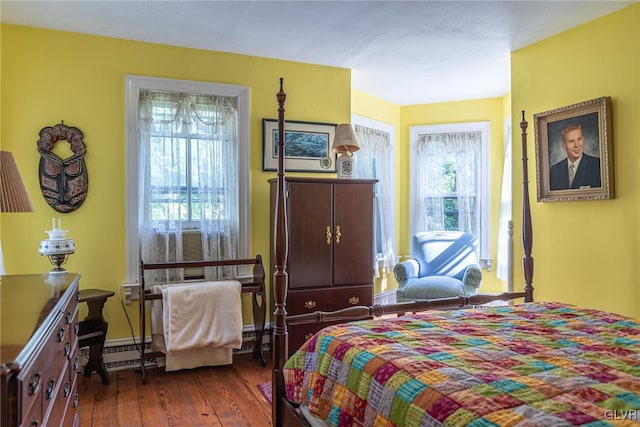 bedroom with baseboard heating and dark wood-type flooring