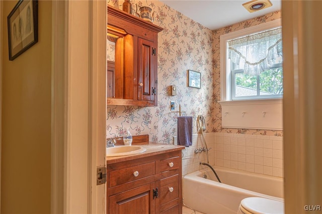 bathroom featuring a bathing tub, toilet, and vanity