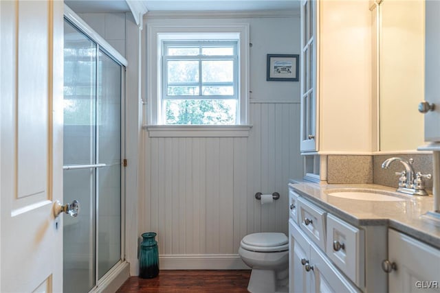 bathroom with vanity, hardwood / wood-style flooring, an enclosed shower, and toilet