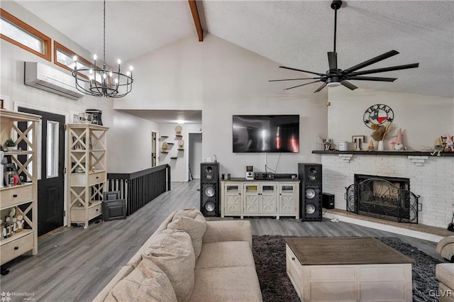 living room featuring wood-type flooring, a textured ceiling, an AC wall unit, beam ceiling, and a brick fireplace