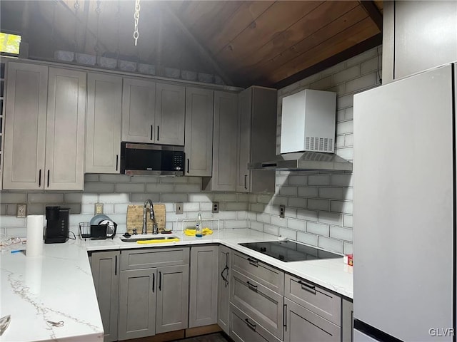 kitchen featuring gray cabinetry, sink, wall chimney range hood, and white refrigerator