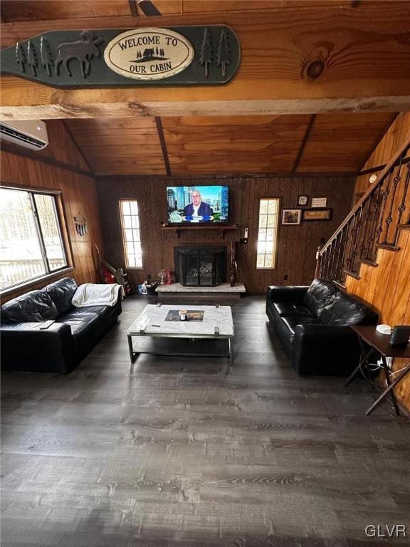 living room with wood walls, lofted ceiling with beams, a healthy amount of sunlight, and a wall mounted air conditioner