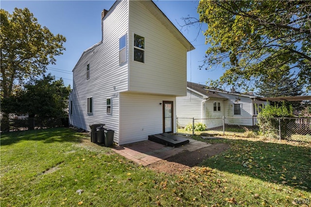 back of house with a lawn and a patio