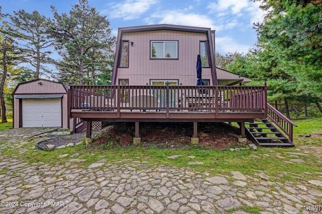 back of property with an outdoor structure, a garage, and a wooden deck