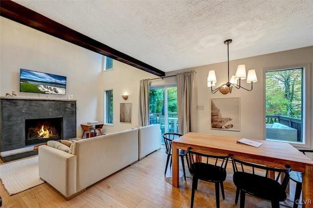 dining space featuring a textured ceiling, beam ceiling, and a wealth of natural light