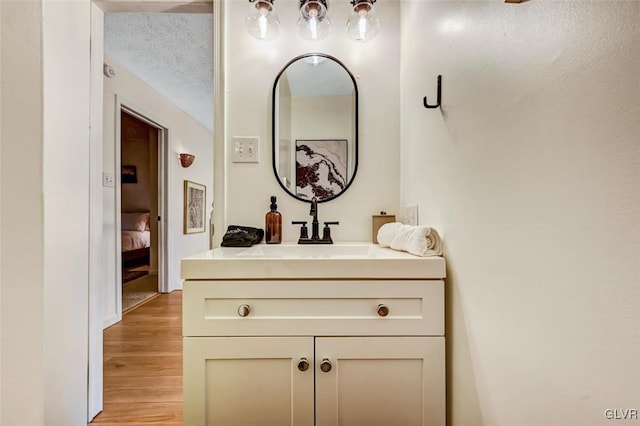 bathroom featuring vanity, a textured ceiling, and hardwood / wood-style flooring