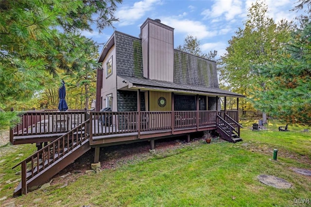 back of property featuring a deck and a yard