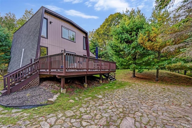 rear view of property featuring a wooden deck