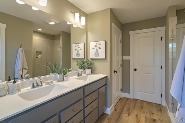 bathroom featuring hardwood / wood-style floors, vanity, and walk in shower