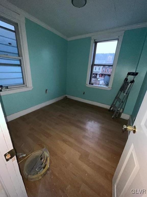 spare room featuring a textured ceiling, hardwood / wood-style floors, and crown molding