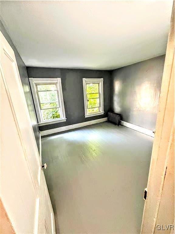 spare room with radiator and concrete floors