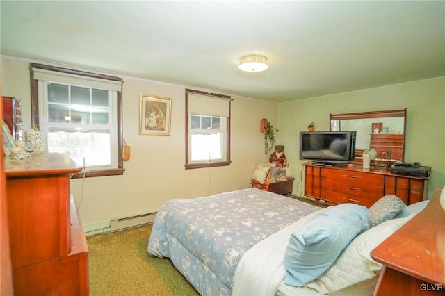 carpeted bedroom featuring a baseboard heating unit and multiple windows