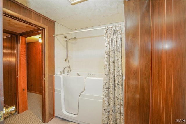 bathroom featuring shower / bath combination with curtain and wooden walls