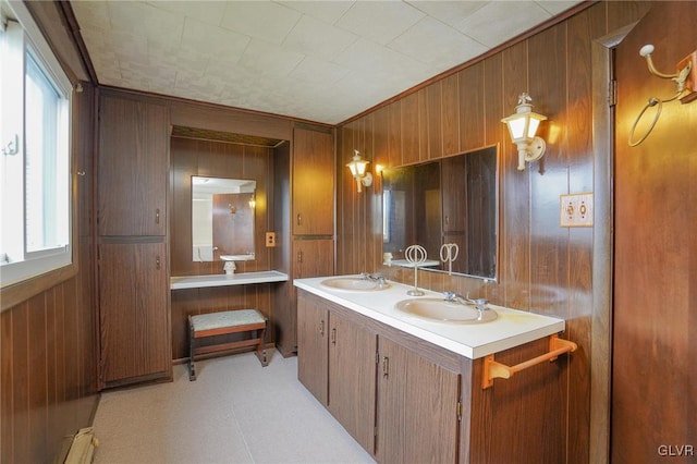 bathroom featuring a baseboard heating unit, wood walls, and vanity