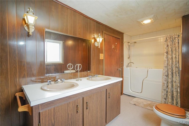 full bathroom featuring shower / bath combination with curtain, vanity, wooden walls, and toilet