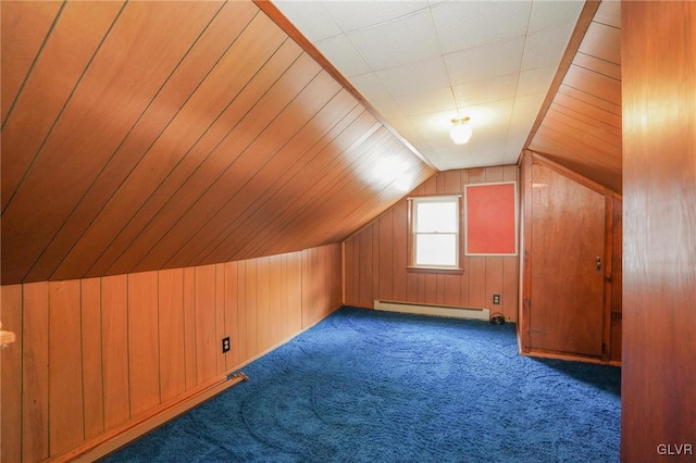 additional living space with wood walls, baseboard heating, and carpet floors