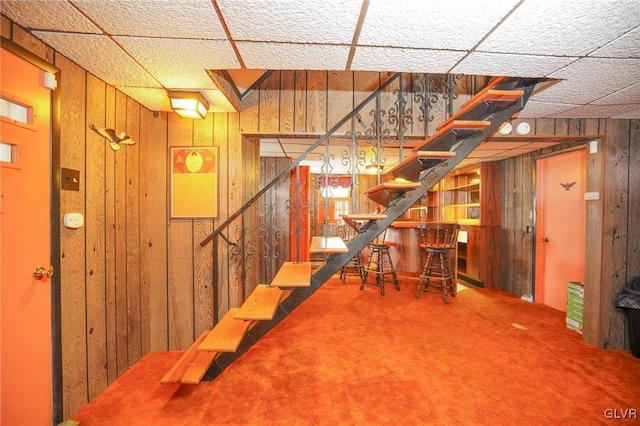 basement with carpet floors and wooden walls