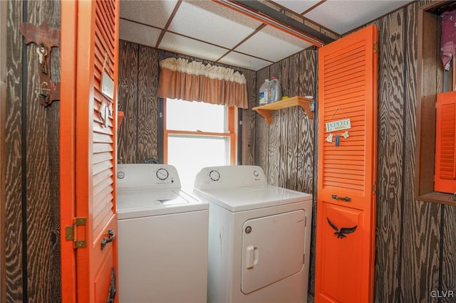 laundry room with wood walls and independent washer and dryer