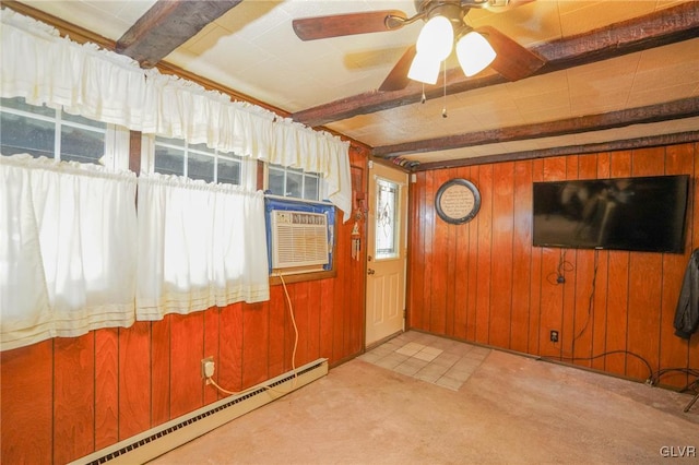 interior space with beam ceiling, ceiling fan, wooden walls, a baseboard heating unit, and light colored carpet