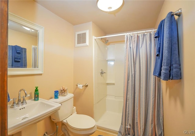 bathroom featuring a shower with shower curtain, sink, and toilet