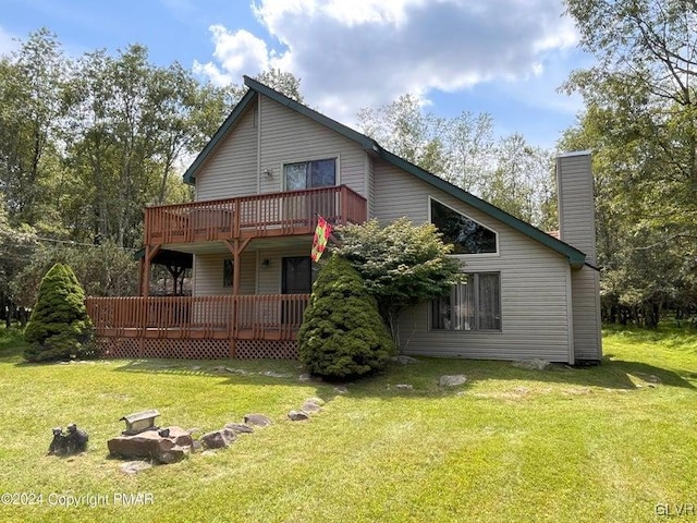 rear view of house with a wooden deck and a yard