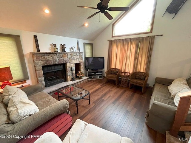 living room featuring ceiling fan, a stone fireplace, dark hardwood / wood-style flooring, and high vaulted ceiling