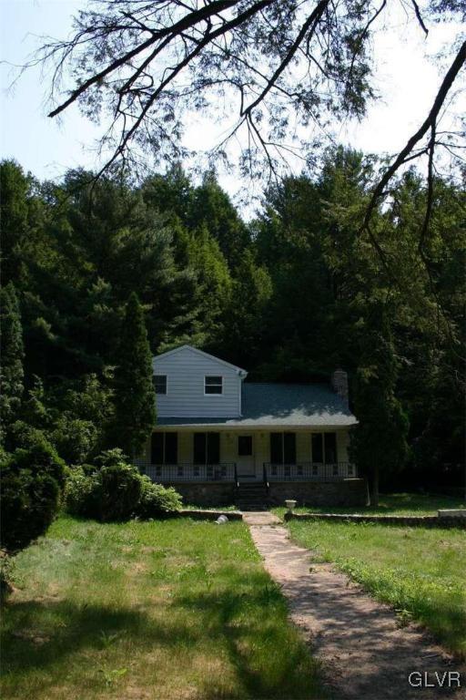 farmhouse inspired home featuring a front lawn and covered porch