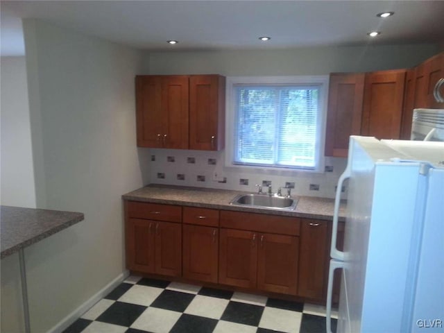 kitchen featuring backsplash, sink, and white fridge