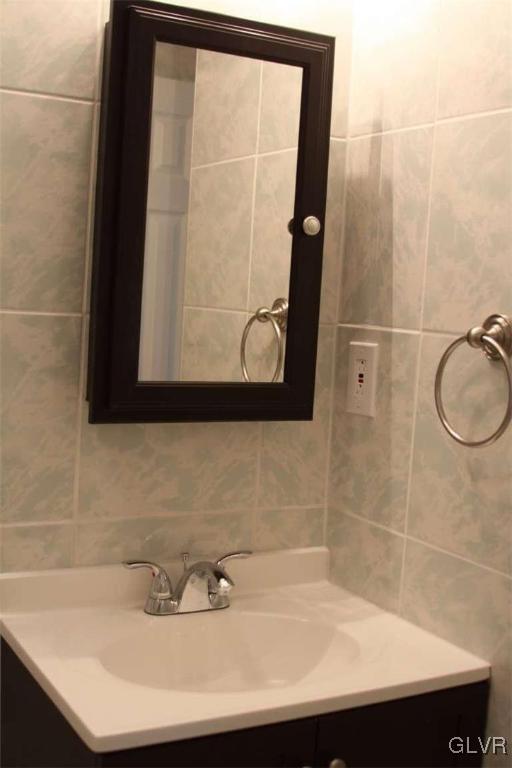 bathroom with tile walls and vanity